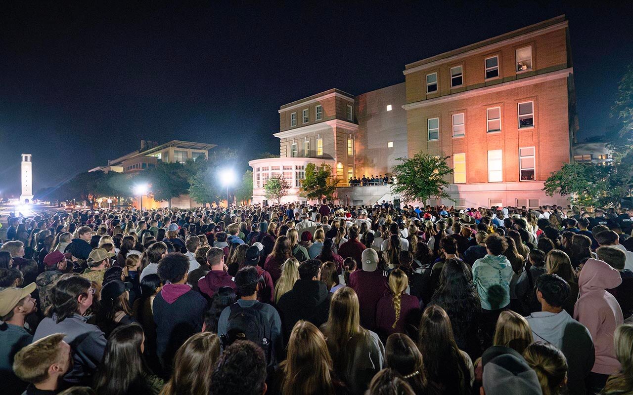 Color photo of a large crowd of Texas A&M students gathered at night during Elephant Walk.