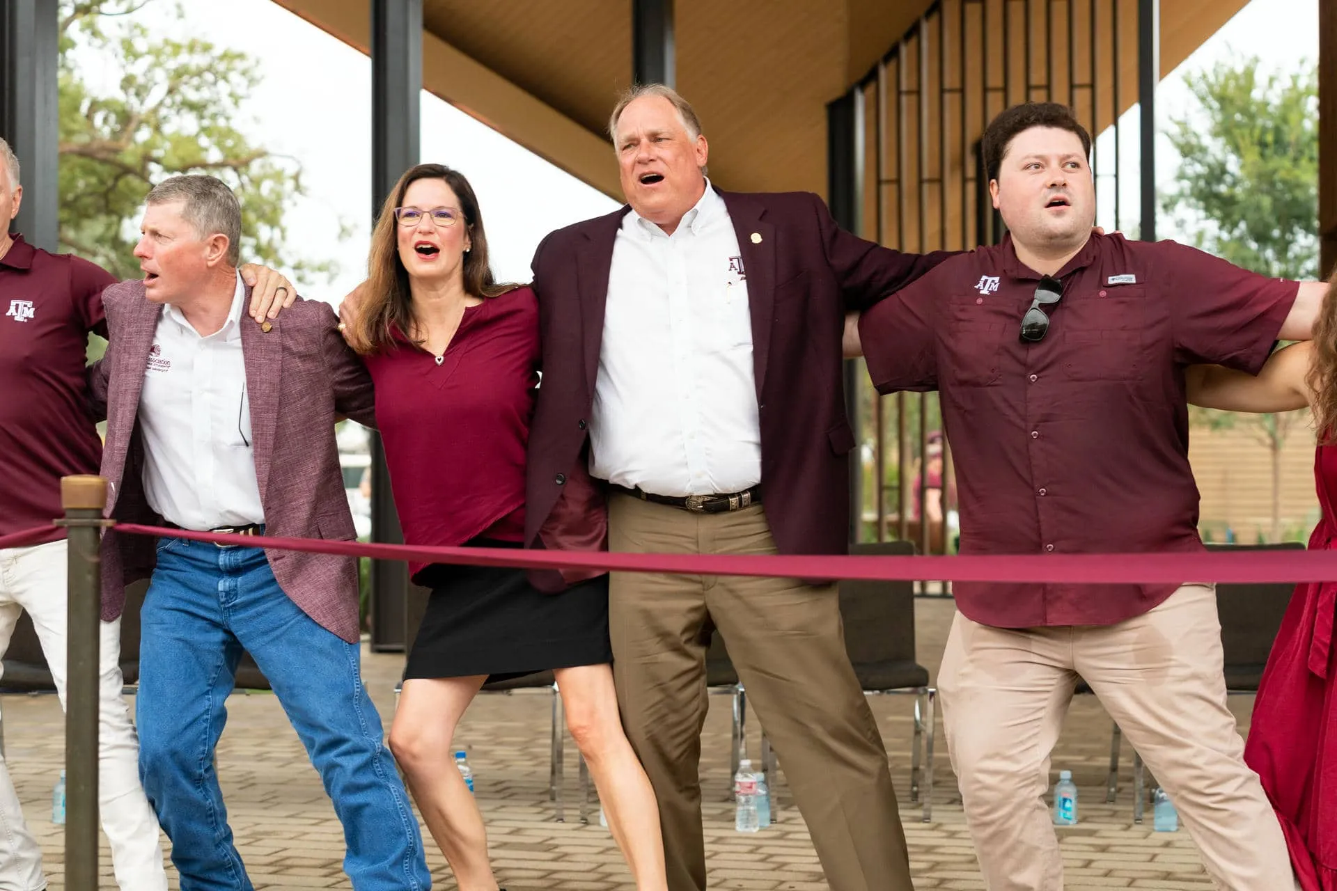 Porter Garner and fellow Aggies sawing a log on the Wood Stage at the Aggie Park opening